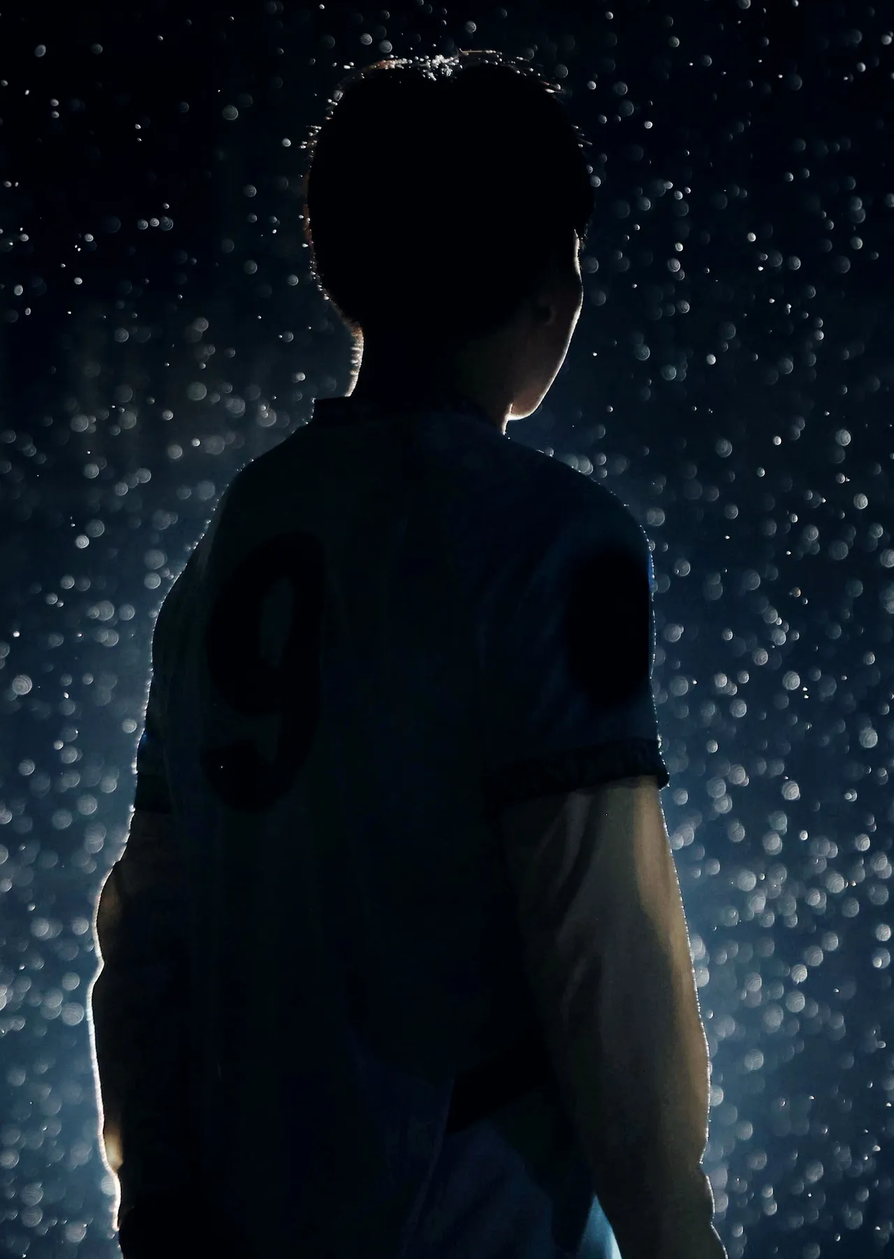 The back of the night third shirt, number 9, soaked under the floodlight.